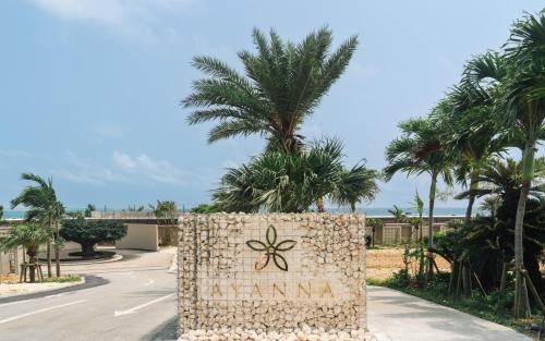 a sign in the middle of a road with palm trees at アヤンナ宮古島 in Miyako Island