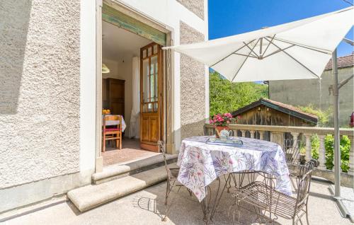 stół i biały parasol na patio w obiekcie Nice Apartment In Loco Di Rovegno w mieście Torriglia