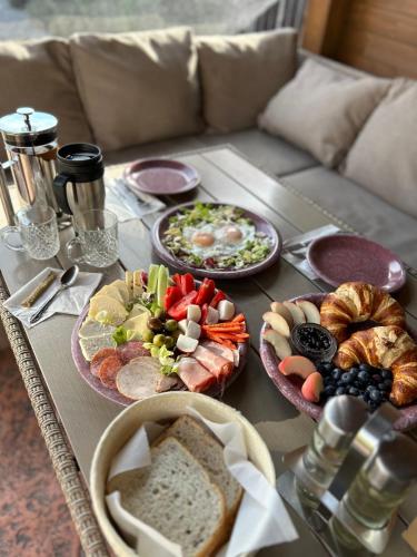 a table topped with plates of food and bread at Residence Rooms Bucovina in Câmpulung Moldovenesc