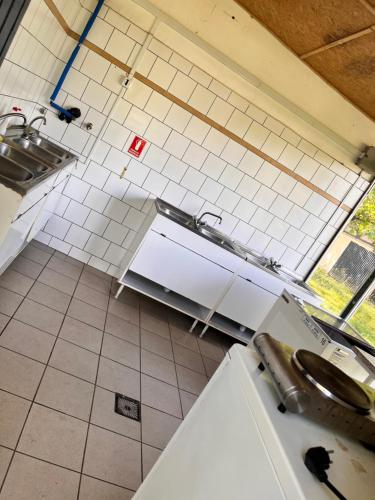 una cocina con paredes de azulejos blancos y una encimera. en Nap kemping 84 parcella en Fonyód