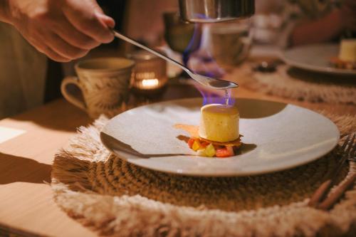 a person holding a spoon and a plate of food at アヤンナ宮古島 in Miyako Island