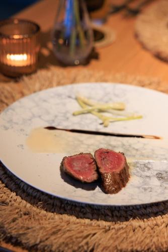 a plate with two pieces of meat on a table at アヤンナ宮古島 in Miyako Island