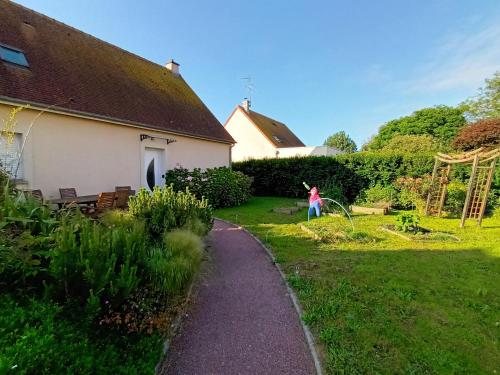 a little girl playing with a kite in a yard at Appartement tout confort in Le Fresne-Camilly