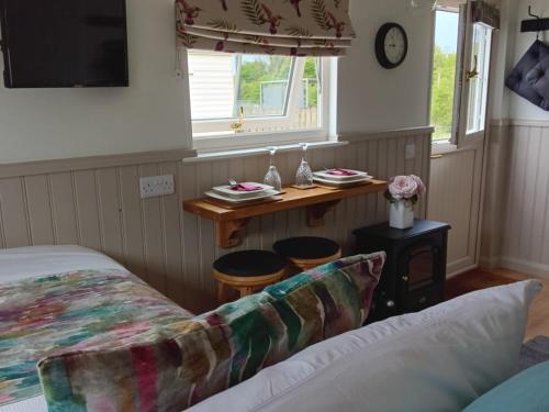 a bedroom with a bed and a table with stools at Shepherd Hut Bird Enniskillen, Fermanagh in Enniskillen