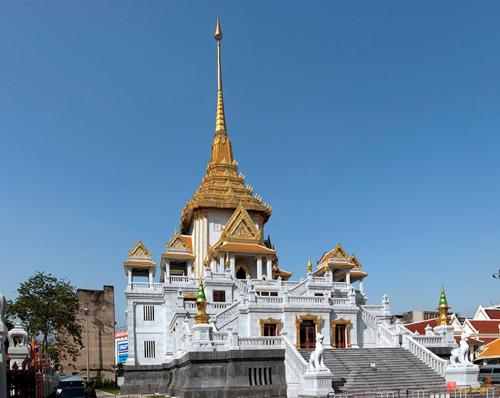 a white building with a gold steeple on top of it at Caiyong Hometel & Cafe's Studio in Khlong San