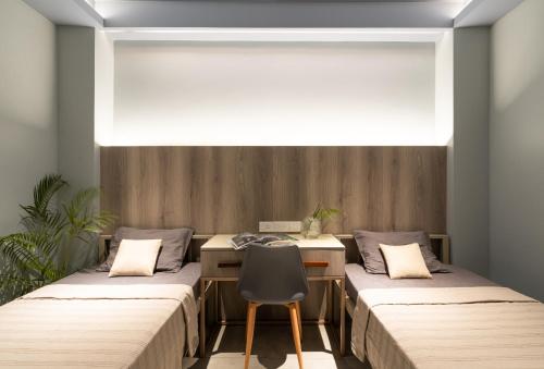 2 camas en una habitación con escritorio y silla en YMCA International Guest House, en Trichūr