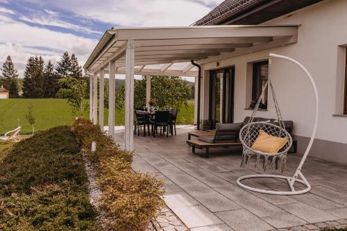 a patio with a porch with a swing at Dzikowiejsko in Bardo