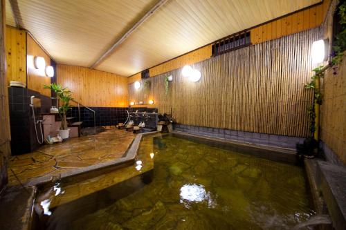 una camera con una piscina d'acqua in un edificio di 日本旅館　松亀荘 a Beppu