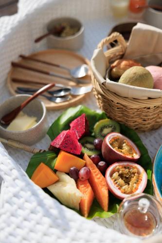 a plate of food with fruits and vegetables on a table at アヤンナ宮古島 in Miyako Island