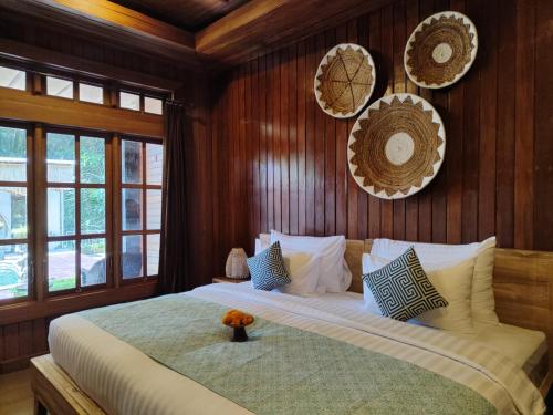 1 dormitorio con 1 cama grande y paredes de madera en Tattva Ubud Retreat & Wellness en Ubud