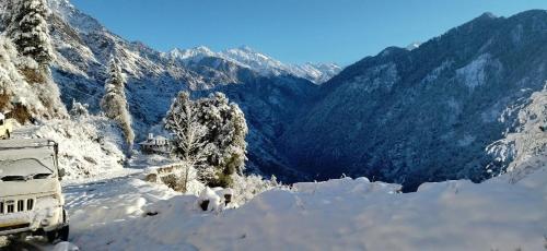 a truck covered in snow on a snowy mountain at Fresh View Homestay in Sainj