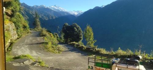a dirt road on a hill with mountains in the background at Fresh View Homestay in Sainj