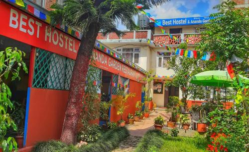 a hotel with a palm tree in front of a building at Best Hostel in Kathmandu