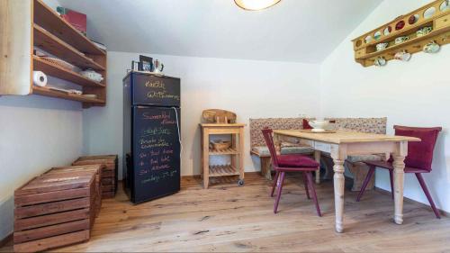 a dining room with a table and a chalkboard at Ferienwohnung Sonnenkind Altaussee in Altaussee