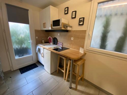 une petite cuisine avec une table et une fenêtre dans l'établissement Studio Numéro 3, à Villeneuve-lès-Avignon