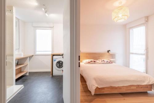 ein Schlafzimmer mit einem Bett und einer Waschmaschine in der Unterkunft Superbe T2 gare Annemasse avec Garage et balcon in Ville-la-Grand