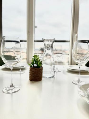 - une table avec des verres à vin et une plante en pot dans l'établissement M16 Superbe T2 gare Annemasse avec Garage et balcon, à Ville-la-Grand