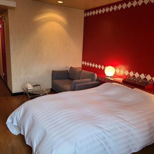 a bedroom with a large bed and a couch at ホテルコメット in Kurashiki