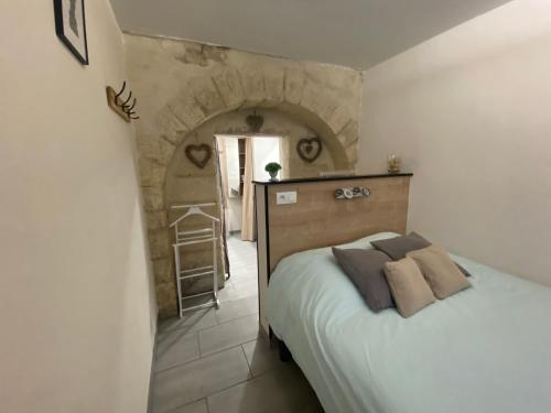 une chambre avec un lit et un mur en pierre dans l'établissement Studio Numéro 3, à Villeneuve-lès-Avignon