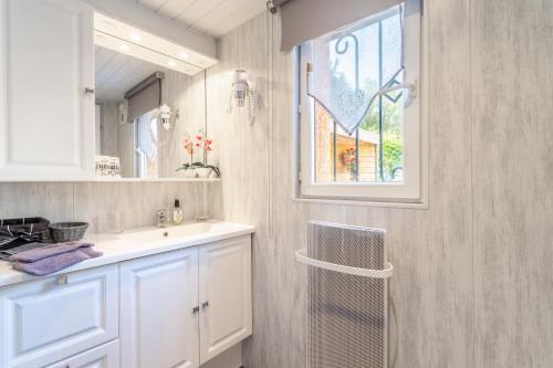 a bathroom with a sink and a mirror and a window at Logis Du Conflent in Rodès