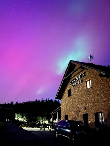 a car parked in front of a building with a purple sky at Pension Libá in Libá