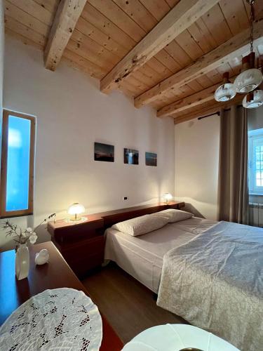 a bedroom with a bed and a table with two lamps at Pucino apartments in Trieste