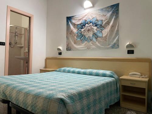 切塞納蒂科的住宿－Piccolo Hotel，卧室配有一张床,墙上挂有绘画作品