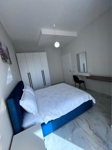 a bedroom with a white bed and a desk at Prime Luxury Apartments in Lushnjë