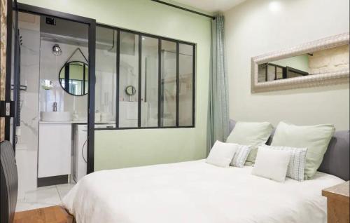 une chambre avec un grand lit blanc et une salle de bain dans l'établissement VERY CHARMING AND COSY FLAT, center of Paris, à Paris