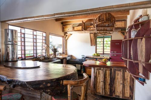 a kitchen with wooden counters and tables and windows at Shambala Madagascar: Beachfront Lodge And Adventures in Ambolobozo