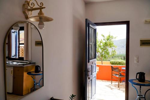 a hallway with a mirror and a kitchen and a patio at Taxiarchis in Symi