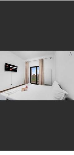 a bedroom with a white bed and a window at Apartament Sunshine in Năvodari
