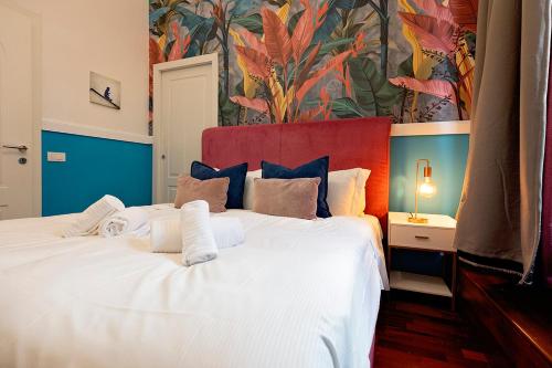a bedroom with a large white bed with a colorful wall at Casa Bella Pantheon in Rome