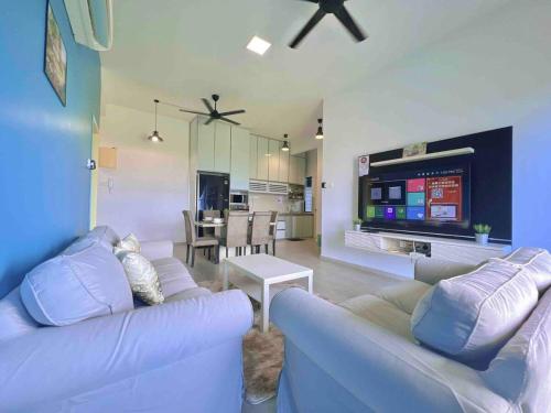 uma sala de estar com um sofá e uma televisão em Atlantis Residences Melaka em Malaca