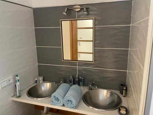 y baño con 2 lavabos, espejo y toallas. en La villa des deux mers, en Tánger