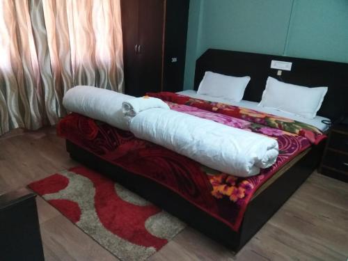a bed in a room with a red blanket on it at Menda-La in Tawang