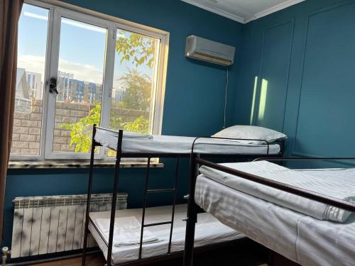 une chambre avec trois lits superposés et une fenêtre dans l'établissement City hostel Almaty, à Almaty