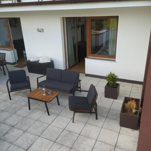 a patio with couches and a table and chairs at Apratmán Julie – Bavorská Ruda in Bayerisch Eisenstein