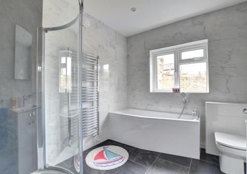 a bathroom with a shower and a tub and a toilet at Hen Ysgol in Beaumaris