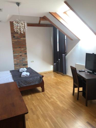 Habitación con cama, mesa y escritorio. en Hotel Gość w dom 