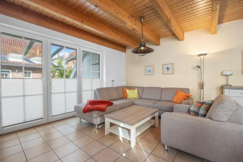 uma sala de estar com um sofá e uma mesa em Ferienhaus Westermann em Hooksiel