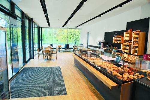 panadería con barra con pasteles y mesas en Business Motel Feldkirch, en Feldkirch