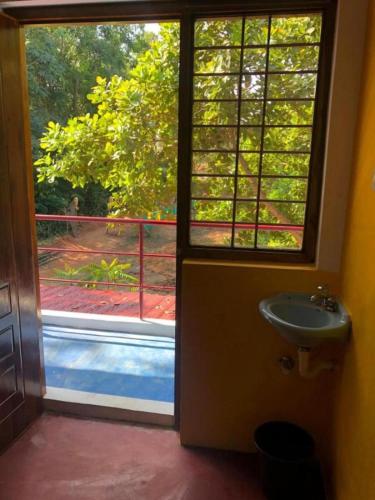 a bathroom door with a window and a sink at Travellers Crib by Crib community in Auroville