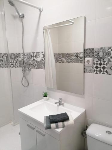 a white bathroom with a sink and a mirror at El Hostalito in Ontinyent