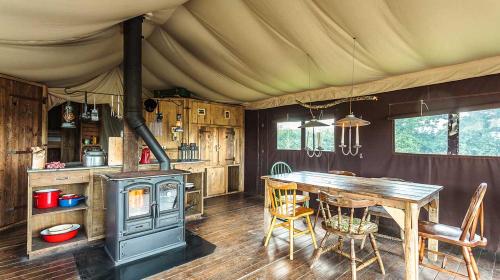 une cuisine avec une table et une cuisinière dans une tente dans l'établissement Ecolodge Terre et Eau, à Sevremont