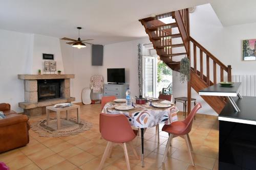 un salon avec une table et une cheminée dans l'établissement La Jouvence - Maison à 10min de la mer, à Créhen
