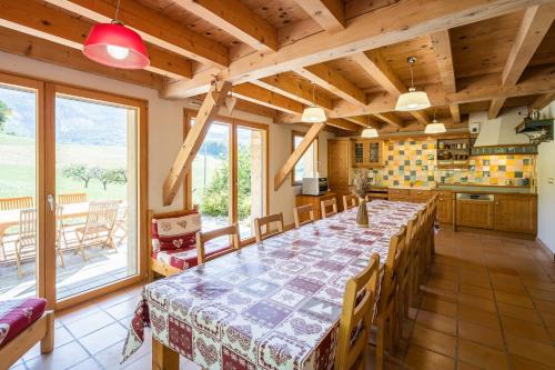 une grande cuisine avec une grande table et des chaises dans l'établissement La Grange aux écureuils, à Montagnole