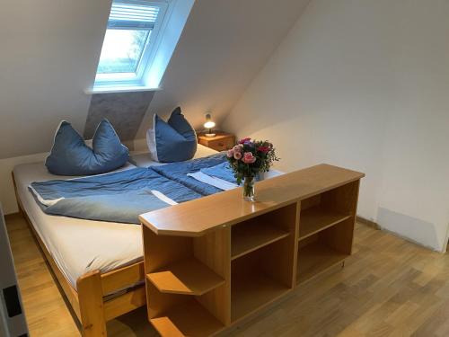 a bedroom with a bed with a vase of flowers on a table at Ferienwohnung Currle in Wangerland