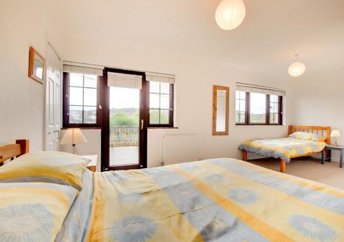 1 dormitorio grande con 2 camas y ventana en Dirleton, en Saundersfoot
