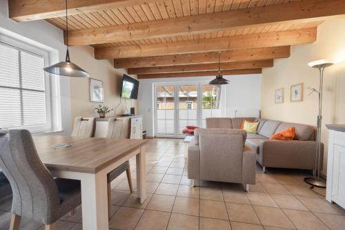uma cozinha e sala de estar com uma mesa de madeira e cadeiras em Ferienhaus Westermann em Hooksiel